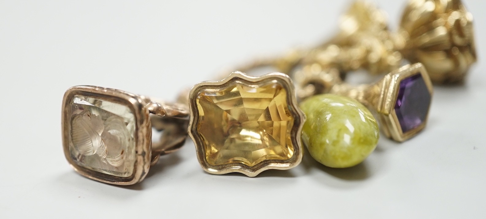 Four Victorian assorted yellow metal and gem set fob seals, including two amethyst(one carved with initials), one citrine and one carnelian (carved with monogram), together with a stone? charm and a gold plate mounted ci